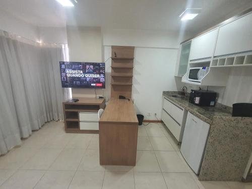 a kitchen with a desk and a television in it at Flat Saint Moritz Express By Rei dos Flats in Brasilia