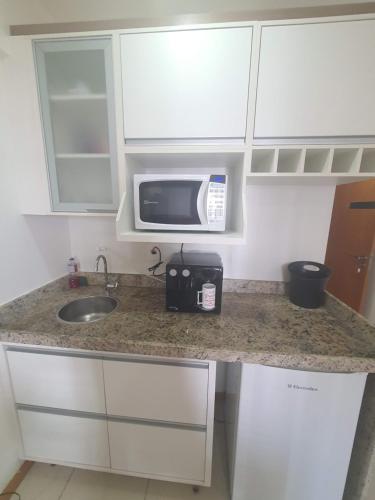 a kitchen with a sink and a microwave on a counter at Flat Saint Moritz Express By Rei dos Flats in Brasilia