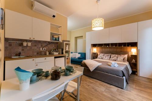 1 dormitorio con 1 cama y cocina con mesa en Le fantasie di Tizi, en Alpignano