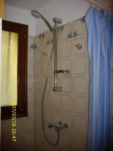 La salle de bains est pourvue d'une douche et d'un rideau bleu. dans l'établissement Résidence Les Estivales Le Cap D'Agde, au Cap d'Agde