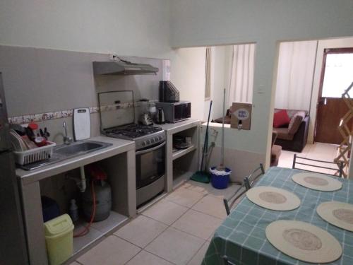 uma cozinha com um lavatório e um fogão forno superior em WAYNA & WAYLLUY em Talara