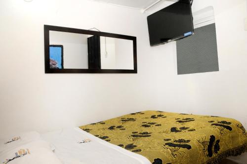 1 dormitorio con cama y espejo en la pared en Hostal Chorro De Quevedo, en Bogotá