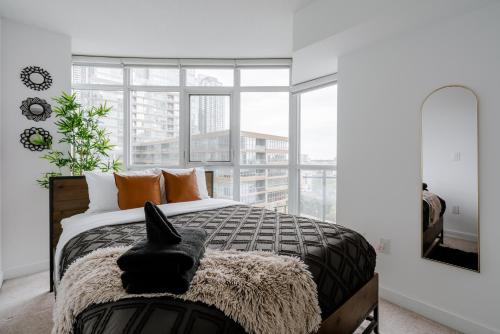 a bedroom with a bed and a large window at The Perfect Getaway in Toronto