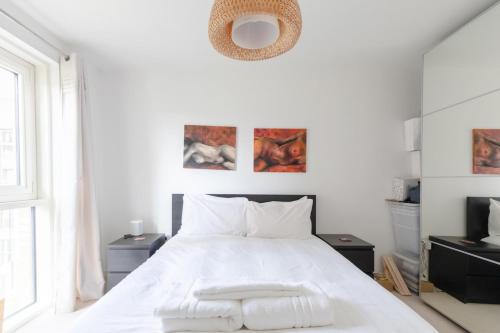 a white bedroom with a white bed and a window at Stunning 1bedroom Flat wBalcony - Surrey Quays! in London