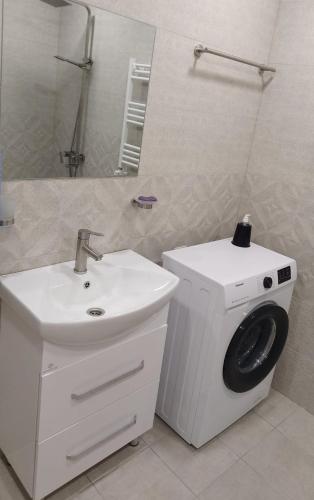 uma casa de banho com uma máquina de lavar roupa e um lavatório em Квартира в центре города Ванадзор em Vanadzor