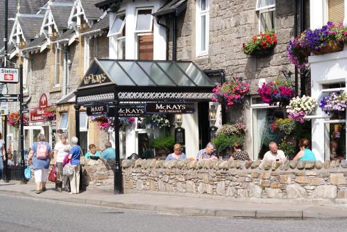 a group of people standing in front of a restaurant at McKays Hotel in Pitlochry