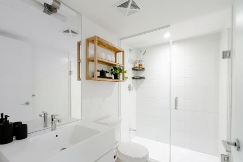 a white bathroom with a shower and a toilet at The Perfect Getaway in Toronto