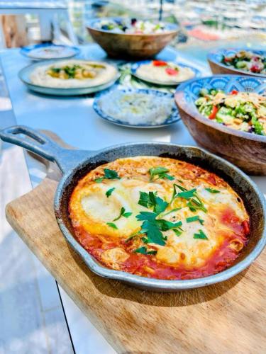 a table with a pizza in a pan on a table at Blue Bay Lifestyle - ex Bali Blue Bay in Balíon