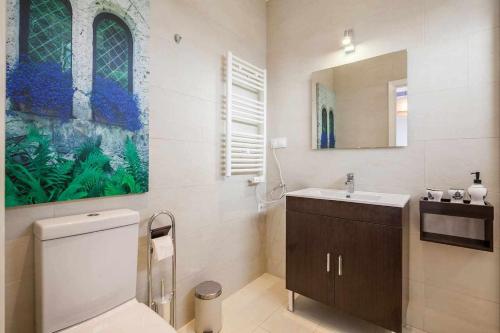 ein Badezimmer mit einem weißen WC und einem Waschbecken in der Unterkunft Renovación total postcovid Netflix Piscinadeco in Las Pajanosas
