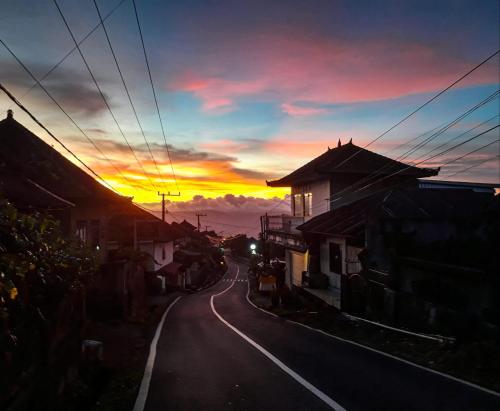 an empty street with a sunset in the background at Keala de Bali in Munduk