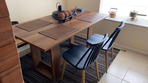 a wooden table with two chairs in a kitchen at Hermosa Casa en buen barrio residencial in Castro