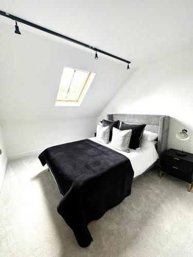 a bedroom with a black and white bed and a window at 2 Bedroomed apt by Sefton Park and Spire Hospital in Liverpool