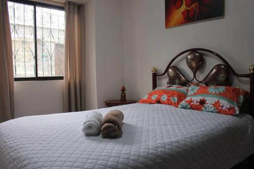 ein ausgestopftes Tier auf einem Bett in einem Schlafzimmer in der Unterkunft Departamento Independiente completo, Centro Histórico Quito in Quito