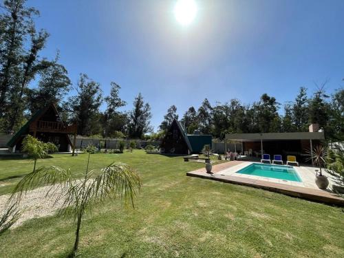 a yard with a swimming pool and a house at Cabañas abuelo pepe in Necochea