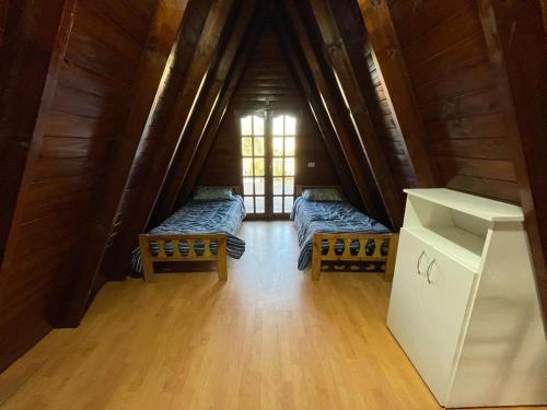 a room with two beds in a wooden house at Cabañas abuelo pepe in Necochea