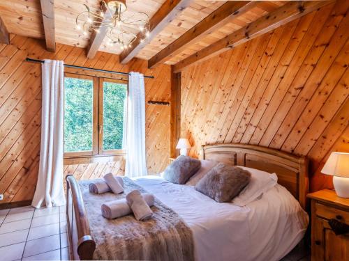 une chambre avec un lit dans une cabane en bois dans l'établissement Chalet de charme 4 ch, garage & cheminée - Morzine - FR-1-754-16, à Morzine