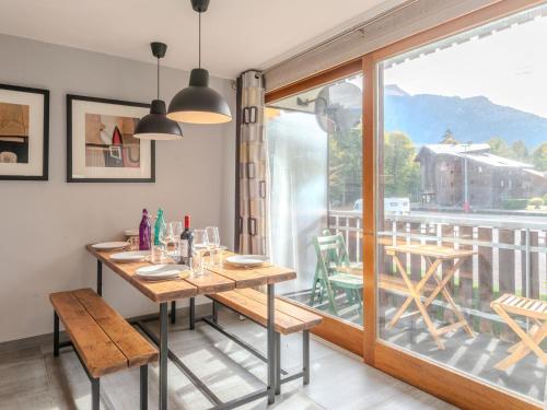 une salle à manger avec une table et une grande fenêtre dans l'établissement Appartement rénové 3 pièces avec balcons, proche pistes et centre de Morzine - FR-1-754-68, à Morzine