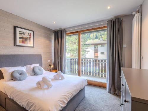 une chambre avec un lit et une grande fenêtre dans l'établissement Appartement rénové 3 pièces avec balcons, proche pistes et centre de Morzine - FR-1-754-68, à Morzine