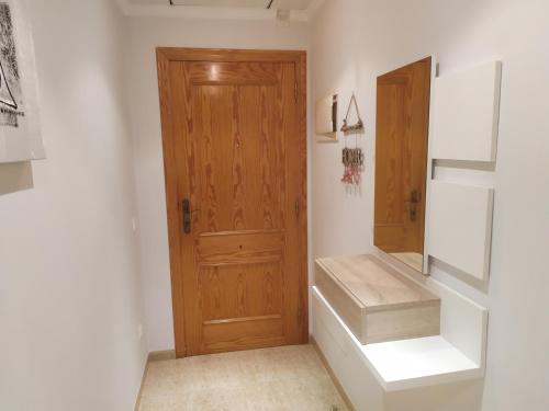 pasillo con puerta de madera y escaleras en una habitación en Apartament Amèrica, en Amposta