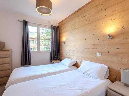 deux lits dans une chambre aux murs en bois dans l'établissement Charmant 4P rénové, 900m centre Morzine, navette, balcon, WiFi, parking, linge fourni - FR-1-754-23, à Morzine