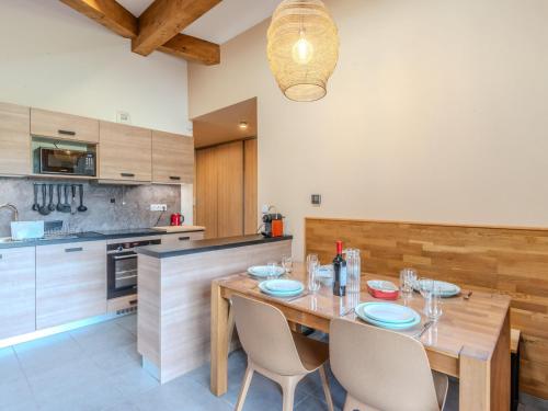 une cuisine avec une table et des chaises en bois dans l'établissement Appartement Neuf 4* à Morzine, 2 Chambres, Proche Pistes et Centre, Balcon, Wifi, Garage Inclus - FR-1-754-45, à Morzine