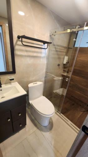 a bathroom with a toilet and a glass shower at 302 Departamento La Terraza in Cuenca