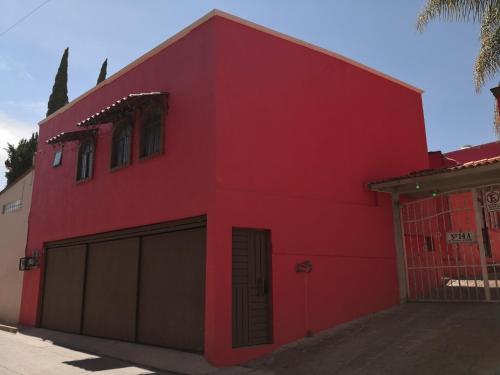 a red house with two garage doors in front at Moderna, Comoda Suite Nube en Tepotzotlán Centro in Tepotzotlán