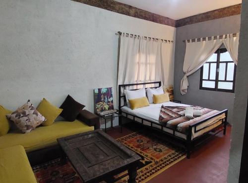 a bedroom with a bed and a couch and a table at Riad dar idsalah in Ouirgane