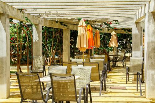 un patio al aire libre con mesas, sillas y sombrillas en Lacqua diRoma I, en Caldas Novas