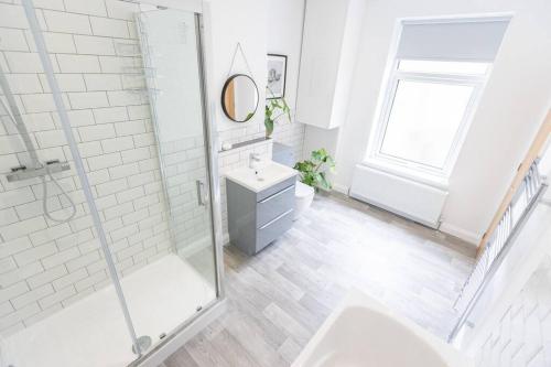 a white bathroom with a shower and a sink at Cambridge Mews - Central Hebden Bridge in Hebden Bridge