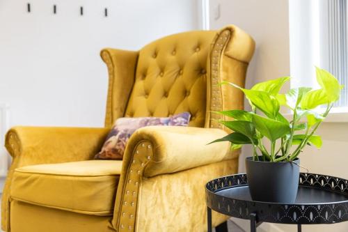 a yellow chair and a table with a potted plant at Cambridge Mews - Central Hebden Bridge in Hebden Bridge