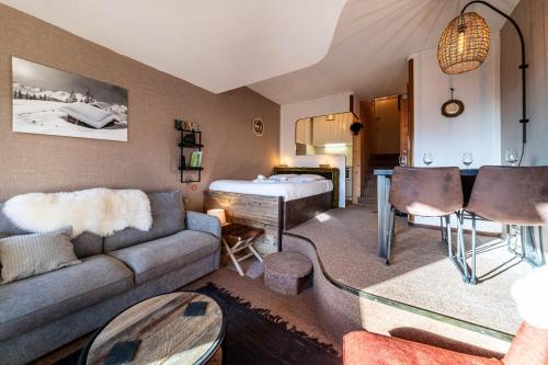 un salon avec un canapé et un lit dans l'établissement Le Cairn, à Avoriaz