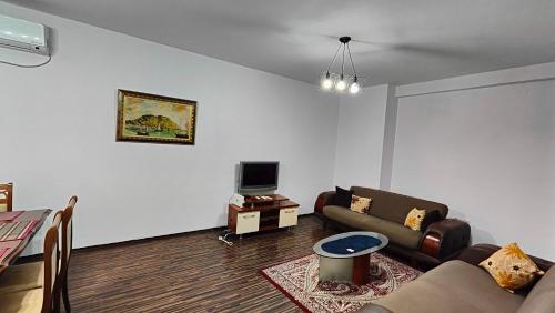 sala de estar con sofá y TV en Appartamento familiare di Toni, en Shkodër