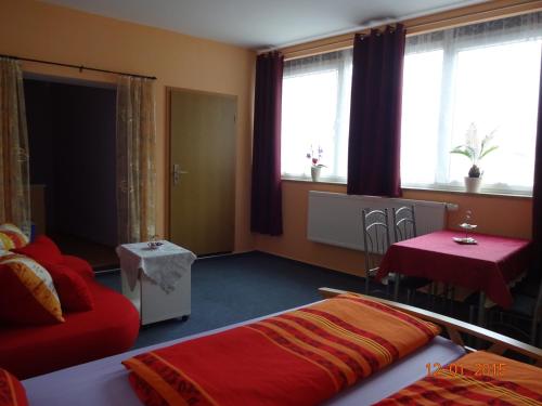 a bedroom with a bed and a table and windows at Ferienwohnung Freund in Weimar