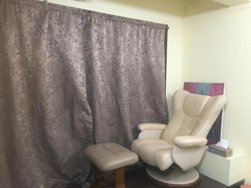 芭達雅南區的住宿－GUNG Apartment，一间带椅子、躺椅和窗户的房间