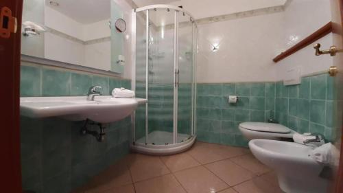 a bathroom with a sink and a shower and a toilet at Sa Rocca Sport e Resort in Guspini