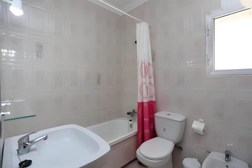 y baño con aseo, bañera y lavamanos. en Villa Familiar con piscina privada y Jardin, en Conil de la Frontera