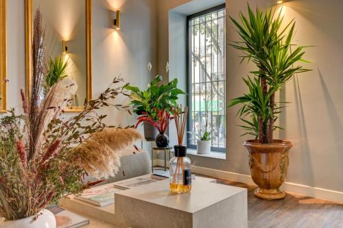 un salon rempli de nombreuses plantes en pot dans l'établissement Boutique Hôtel Provencia, à Marseille