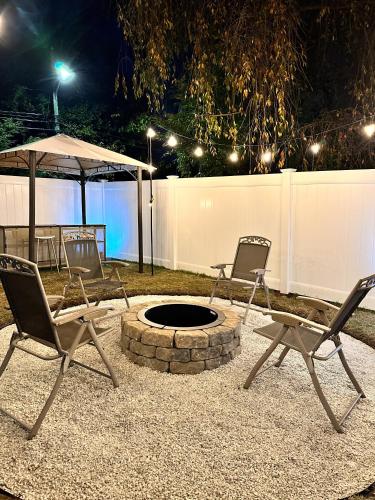 two chairs and a fire pit in a backyard at night at 7 Mins drive to Yale, Large fenced yard in New Haven