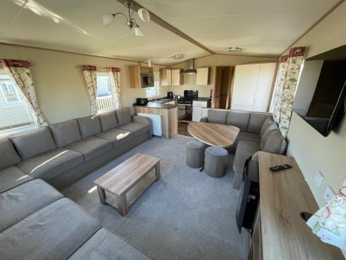 a living room with a large couch and a table at 87 Lancaster Crescent in Tattershall