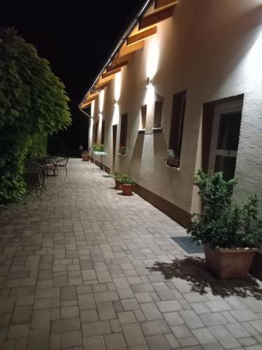 a courtyard of a building at night with potted plants at Flower Bike in Štúrovo