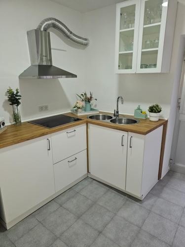 a kitchen with white cabinets and a sink at La encantá in Almodóvar del Río