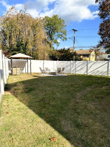 a yard with a fence and a table and chairs at 7 Mins drive to Yale, Large fenced yard in New Haven