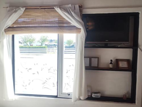 ventana con cortina y TV en una habitación en en patagonia... en Trevelín