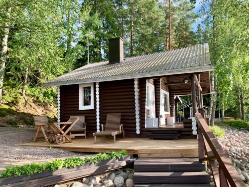 una baita nel bosco con un ponte di legno di Kesäpesä ad Artjärvi
