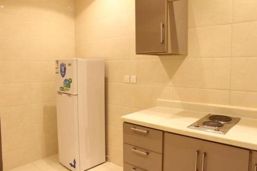 a kitchen with a white refrigerator in a room at فيوبارك للشقق الفندقية in Al Hofuf