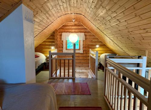 eine Blockhütte mit einer Treppe, die zu einem Schlafzimmer führt in der Unterkunft Kesäpesä in Artjärvi