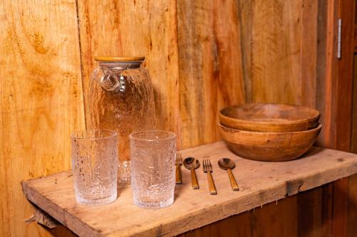 a wooden shelf with two glasses and a bowl at Aparthotel Ayahuaska for SOLO travelers in Iquitos
