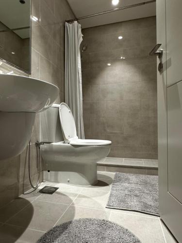 uma casa de banho com um WC, um lavatório e um chuveiro em Forte Downtown Dubai em Dubai