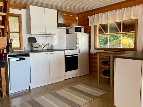 una cucina con mobili bianchi ed elettrodomestici bianchi di Kesäpesä ad Artjärvi